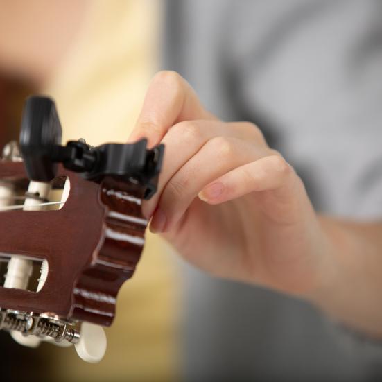 Hånd der stemmer en guitar