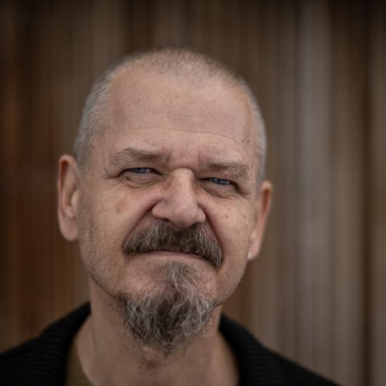 Foto af Kim Leine på en brun baggrund