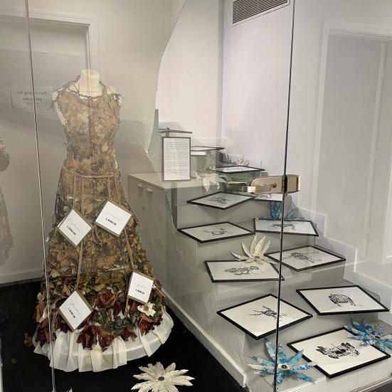 foto af tegninger i ramme og en pyntet mannequin