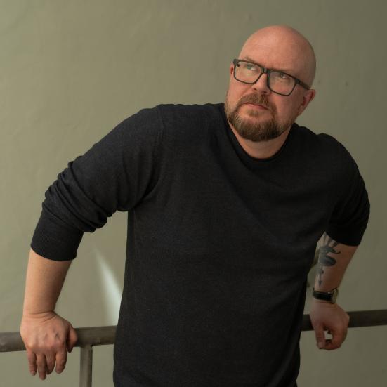 Mand der står på en trappe, ved et jerngelænder