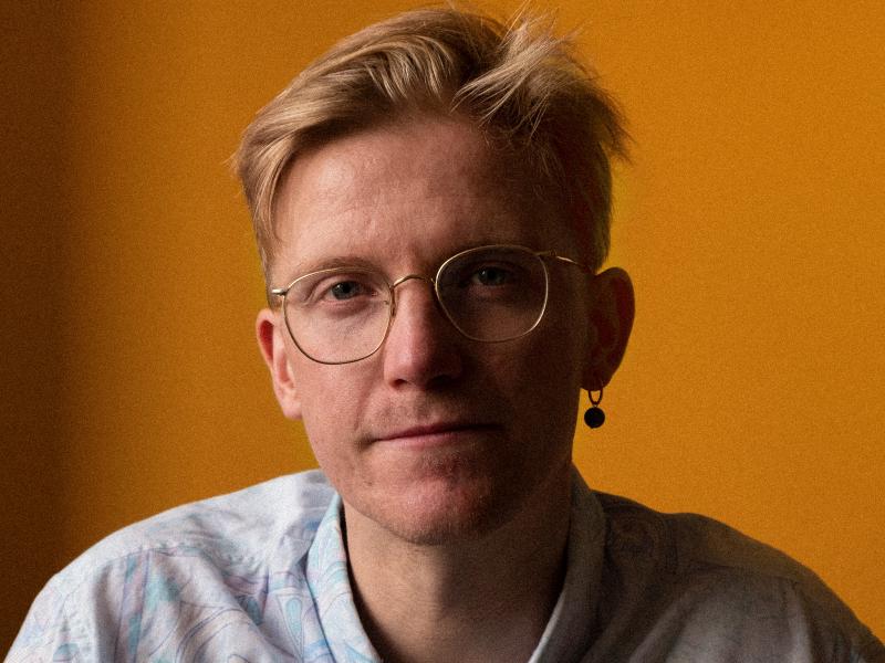 Mand i skjorte og med briller kigger på kameraet