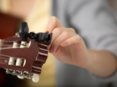 Hånd der stemmer en guitar