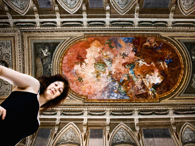 Foto af Cecilie Marie Meyer med stort loftmaleri i baggrunden