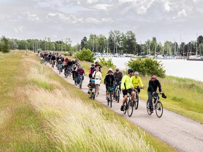Børn og voksne der cykler ved stranden
