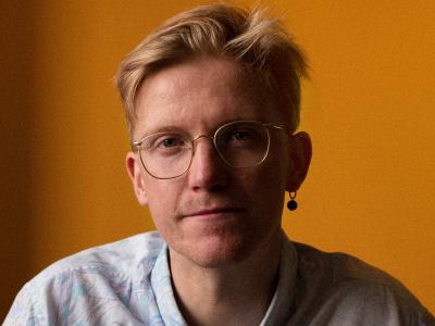 Mand i skjorte og med briller kigger på kameraet