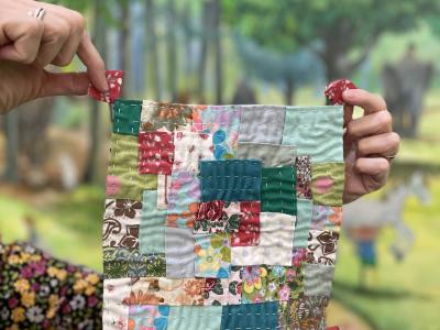 Hænder der holder et patchwork af stof lapper op