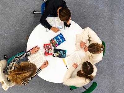 4 unge mennesker sidder omkring et rundt bord