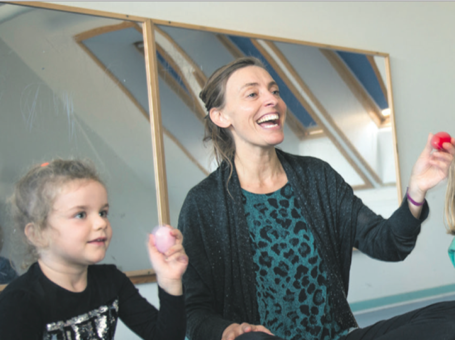 Foto af kvinde og barn der laver musikøvelser på en lys baggrund